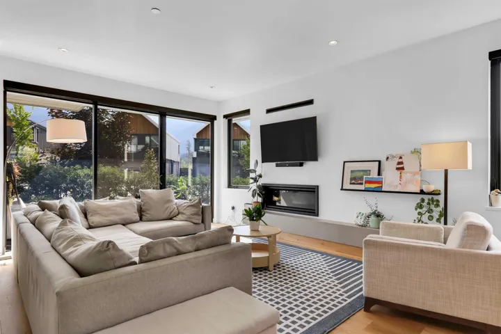 Living area featuring light wood-type flooring, a glass covered fireplace, and recessed lighting