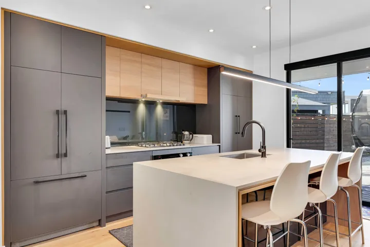 Kitchen with a breakfast bar, recessed lighting, light stone counters, hanging light fixtures, and a kitchen island with sink