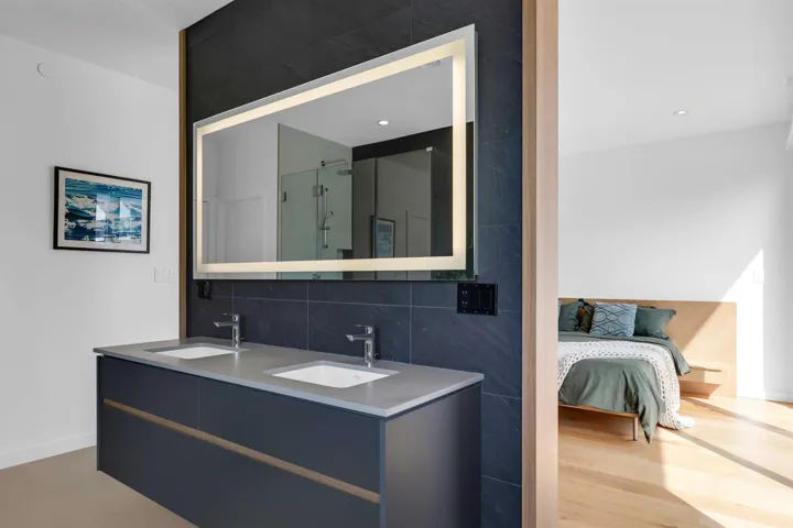 Bathroom with a shower stall, double vanity, backsplash, and recessed lighting