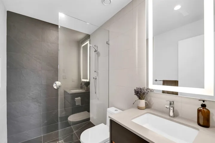 Full bath featuring vanity, tile walls, and tiled shower