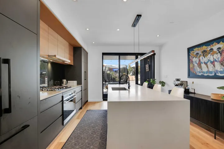 Kitchen with modern cabinets, recessed lighting, light wood-type flooring, and an island with sink