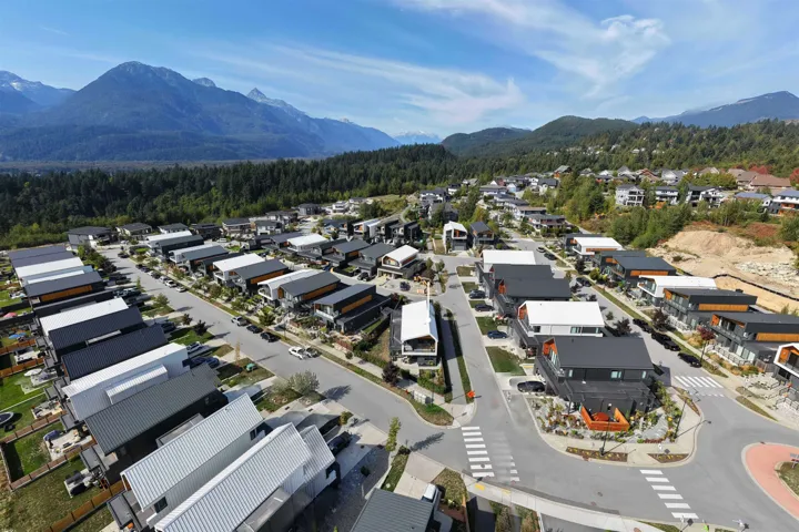 Aerial perspective of suburban area with mountains and a heavily wooded area