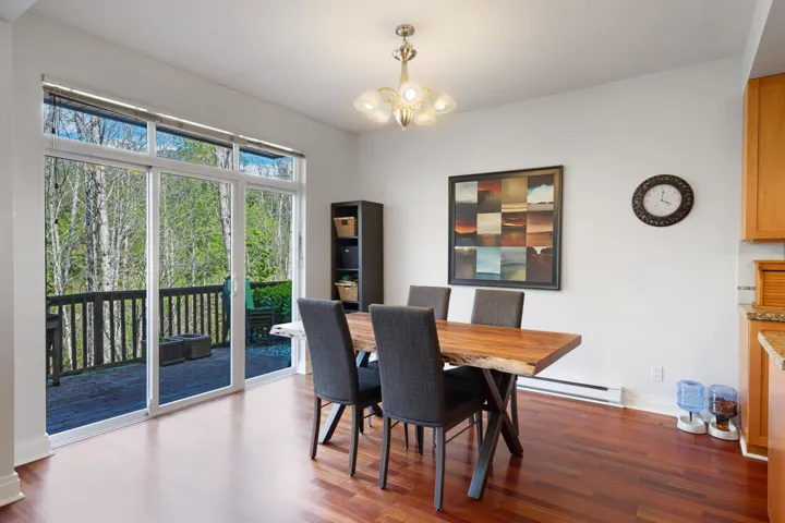 Dining area featuring baseboard heating, a chandelier, wood finished floors, and baseboards