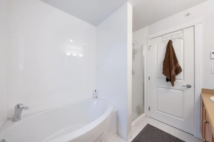Bathroom with a bath, a shower stall, vanity, and tile patterned flooring