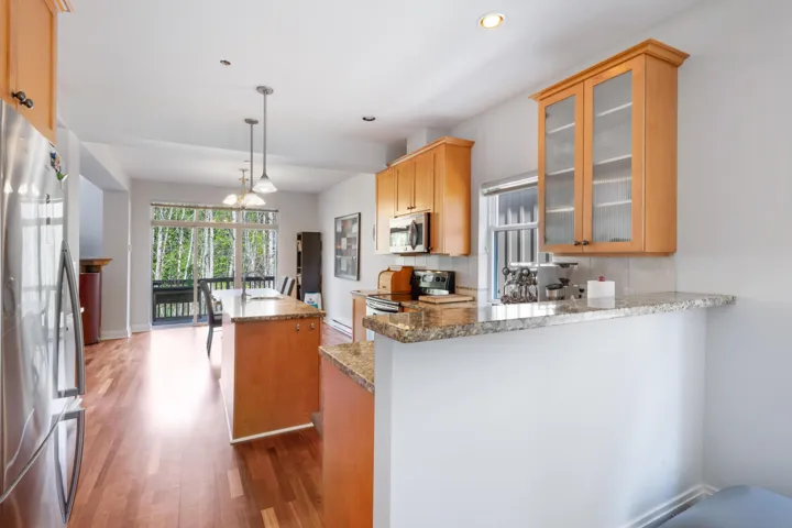 Kitchen with appliances with stainless steel finishes, light wood-style flooring, recessed lighting, a center island, and a peninsula
