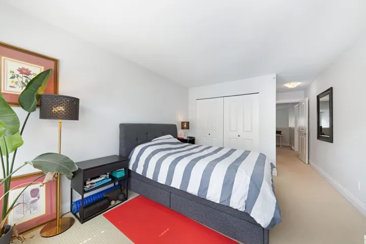 Carpeted bedroom with a closet and baseboards