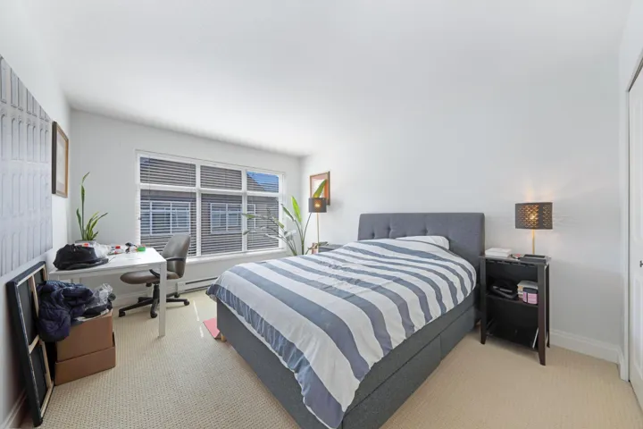 Carpeted bedroom featuring a desk, baseboard heating, and baseboards
