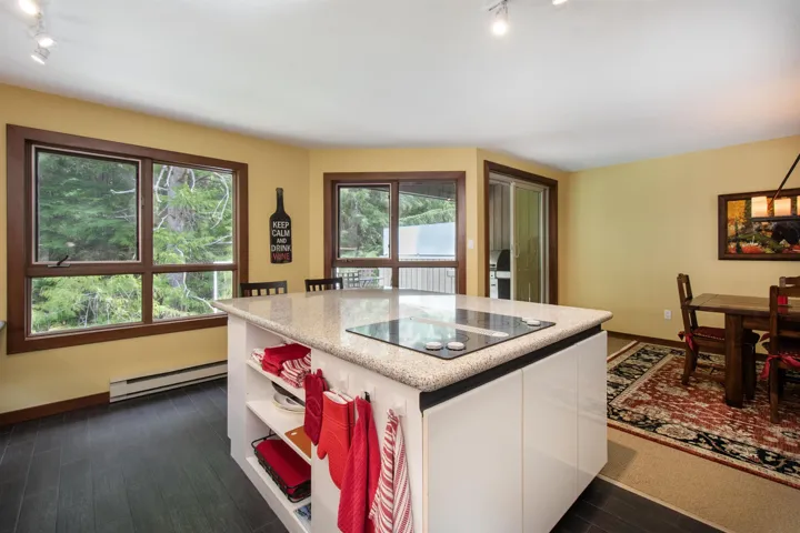 Kitchen island with an integrated cooktop and light-colored countertop