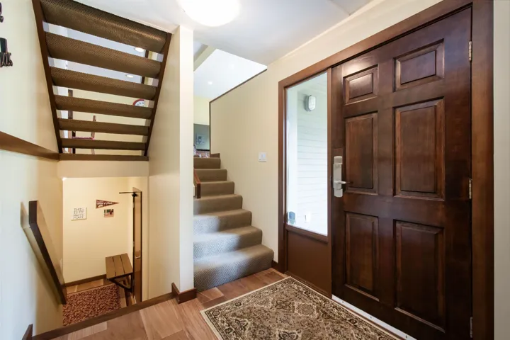 Rich wood-paneled entry door with an adjacent full-length glass sidelight