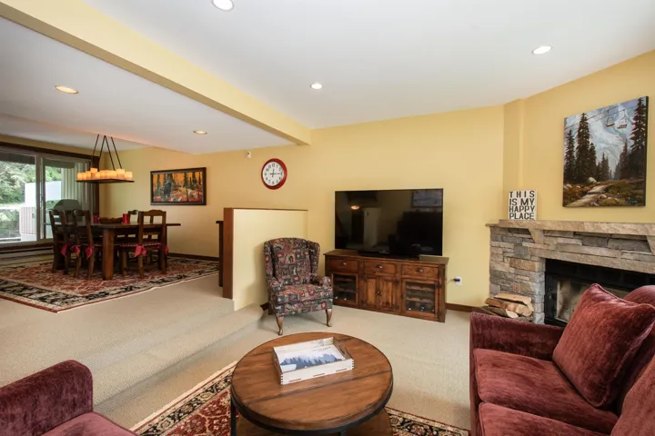 Sunken living room featuring recessed lighting and a stone-faced fireplace with a hearth