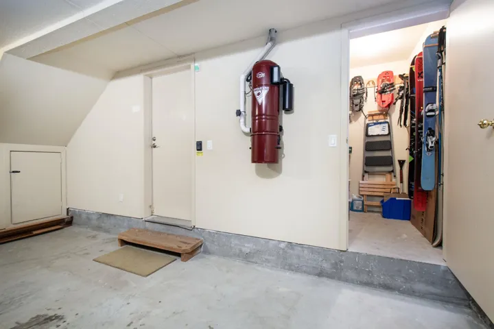 Utility space featuring a central vacuum system, concrete flooring, and an additional storage room