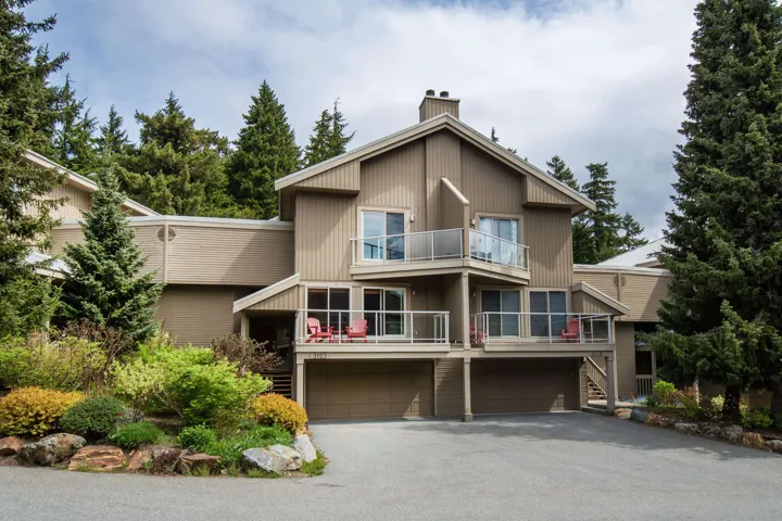 Multi-level property with a neutral-toned exterior, featuring multiple balconies with glass railings