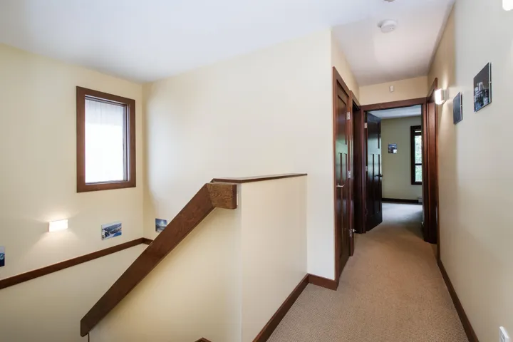 Stair landing featuring a wood-finish handrail and baseboards