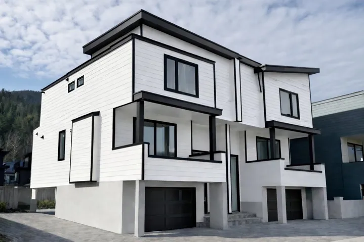 Contemporary house featuring stucco siding, a garage, decorative driveway, and a balcony