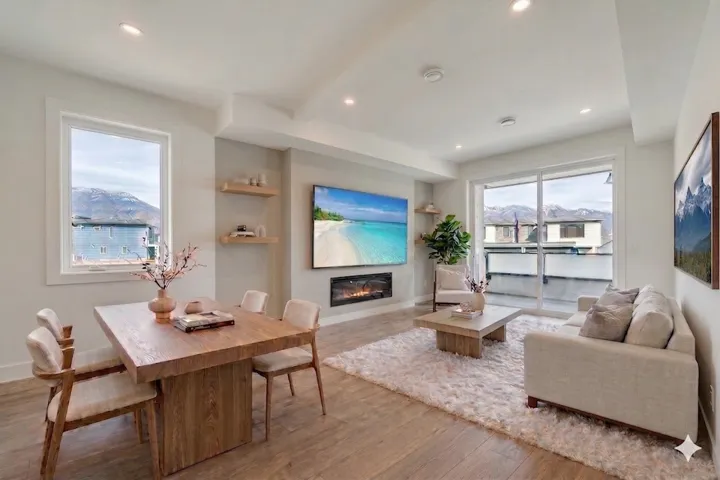 Living room featuring light wood-style floors, built in shelves, a glass covered fireplace, and recessed lighting
