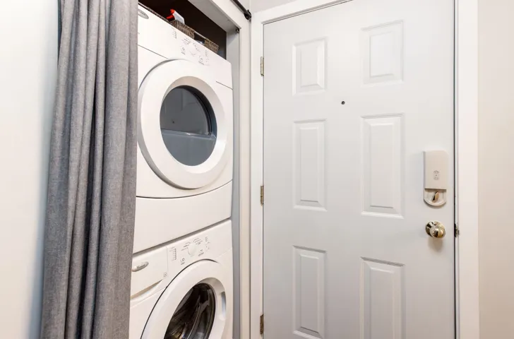 Washroom with stacked washer and clothes dryer