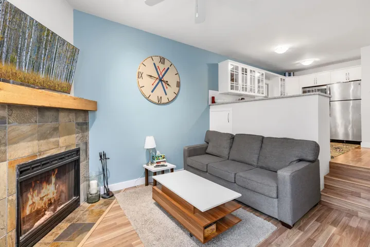 Living room featuring light wood-style floors and a tile fireplace
