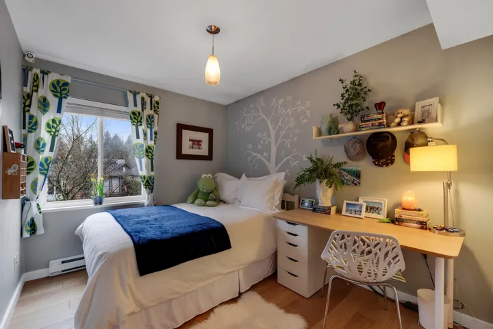 Bedroom with light wood finished floors and baseboard heating