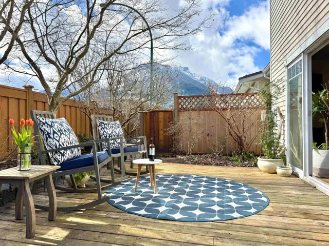 Wooden terrace with a fenced backyard and a mountain view