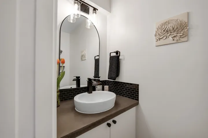 Bathroom featuring vanity and decorative backsplash