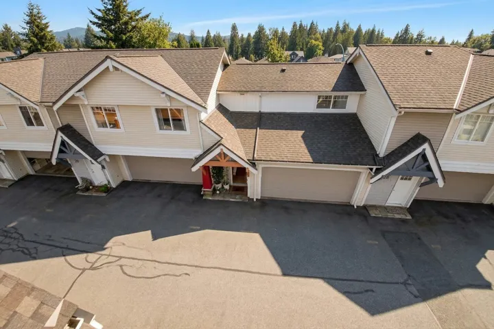 View of front facade with a shingled roof, driveway, and an attached garage