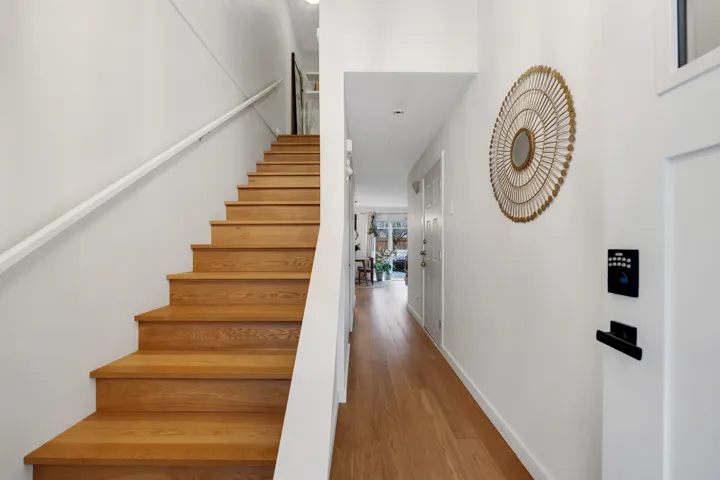 Stairway with wood finished floors and baseboards