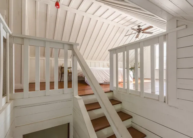 Stairs with a ceiling fan and lofted ceiling