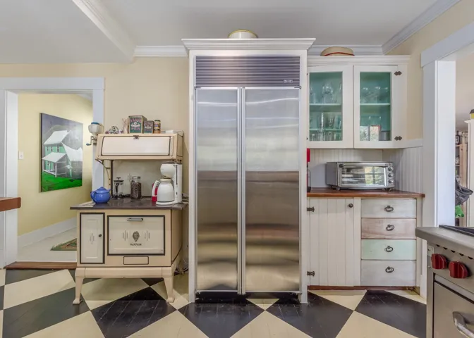 Kitchen with a toaster, built in refrigerator, glass insert cabinets, and ornamental molding