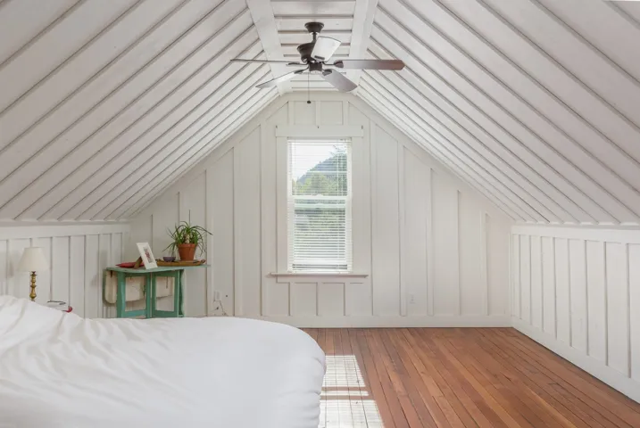 Bedroom featuring a decorative wall, lofted ceiling, and hardwood / wood-style flooring