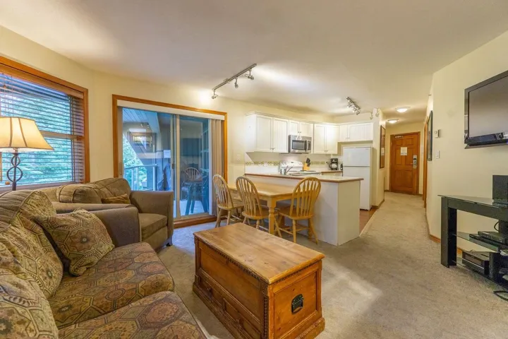 Living area featuring track lighting and light carpet