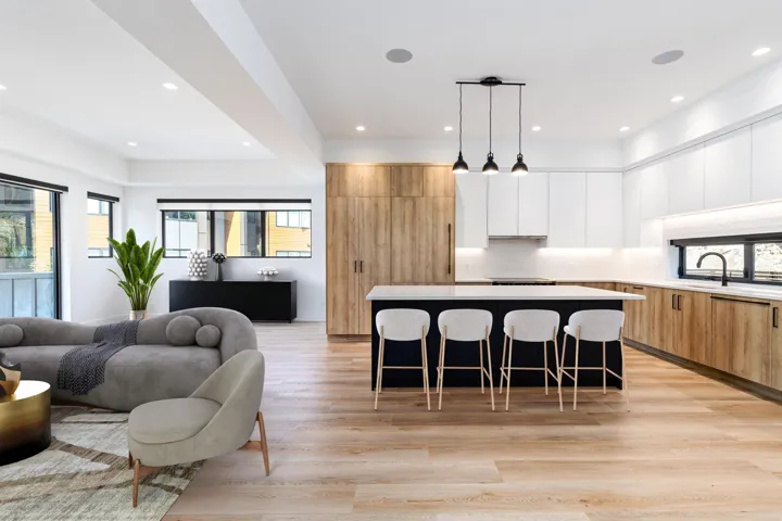 Kitchen with open floor plan, white cabinetry, pendant lighting, a kitchen island, and light wood-style flooring