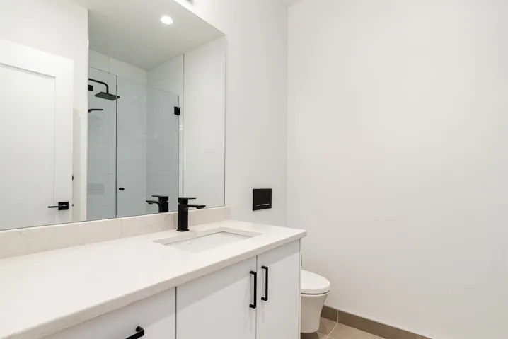Bathroom featuring vanity, a stall shower, light tile patterned floors, and recessed lighting