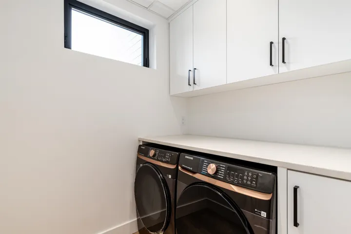 Washroom featuring cabinet space and washer and clothes dryer