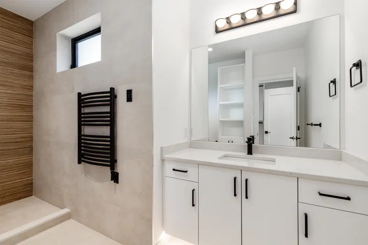 Bathroom featuring vanity, a towel warming rack, and radiator heating unit