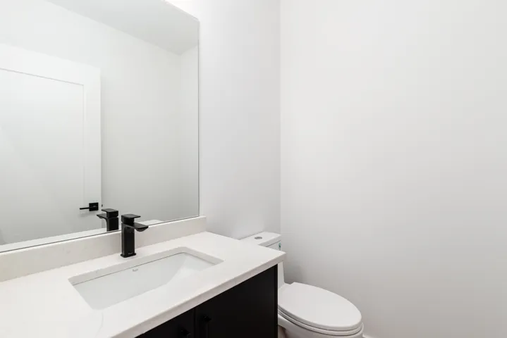 Half bathroom with vanity and toilet
