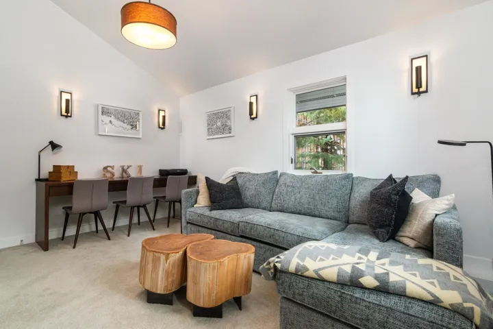 Living room with vaulted ceiling, carpet flooring, and an office area
