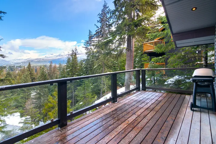 Deck featuring a grill, a mountain view, and a wooded view