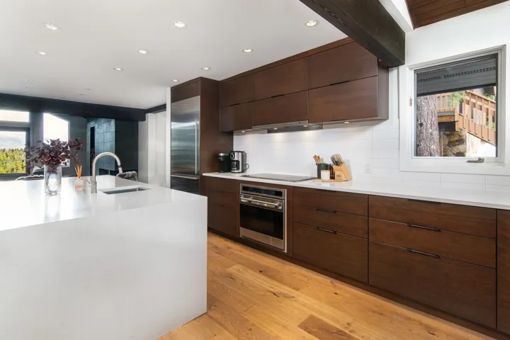 Kitchen with modern cabinets, appliances with stainless steel finishes, light wood-type flooring, dark brown cabinetry, and recessed lighting