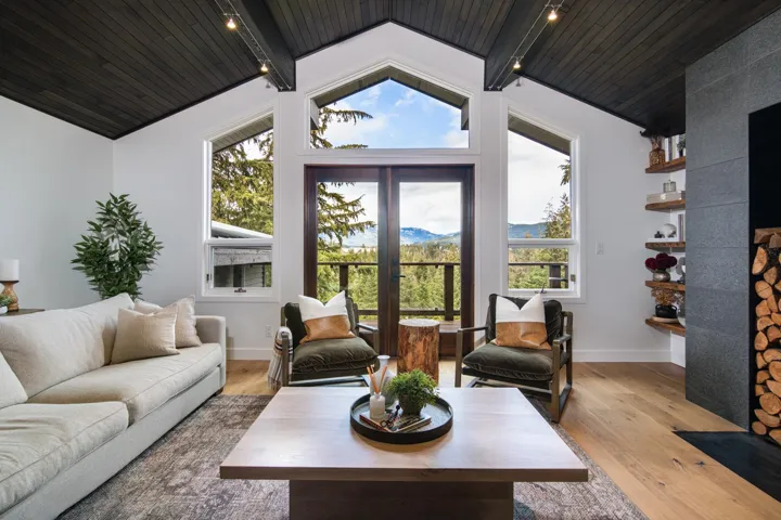 Living area featuring wood finished floors, wood ceiling, a mountain view, and a large fireplace