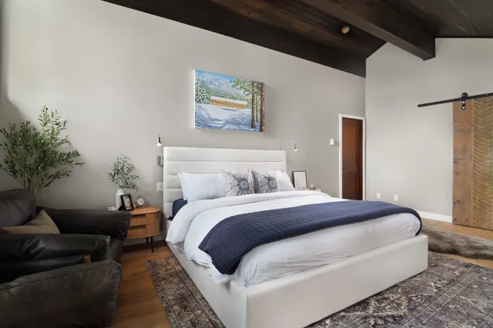 Bedroom with a barn door, wood finished floors, and wood ceiling