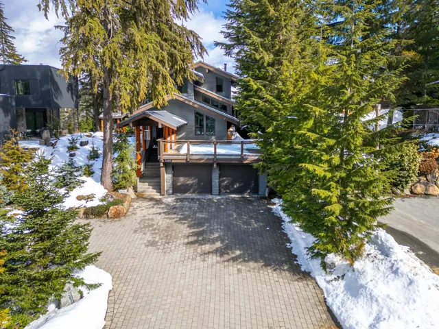 View of front of house featuring decorative driveway, a deck, and a garage