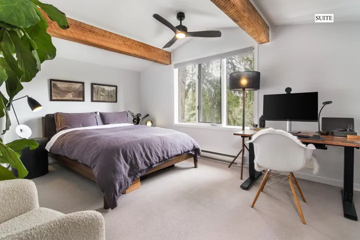Carpeted bedroom featuring a desk, a ceiling fan, and baseboard heating