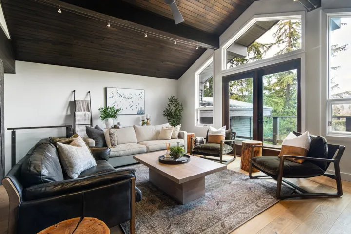 Living area with wood finished floors, a wooden ceiling with exposed beams, and high vaulted ceiling