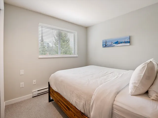 Carpeted bedroom featuring a baseboard heating unit and baseboards