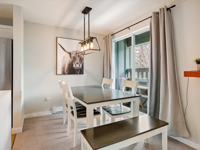 Dining space with a chandelier, light carpet, and baseboards