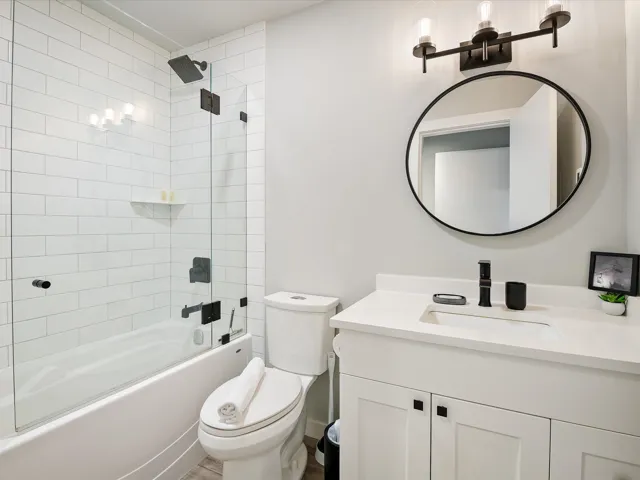 Bathroom with toilet, vanity, and washtub / shower combination