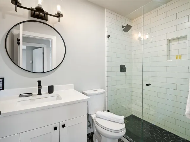 Full bathroom featuring toilet, a stall shower, and vanity