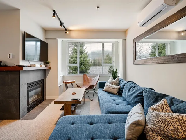 Living room with rail lighting, carpet, a fireplace, and a wall mounted air conditioner