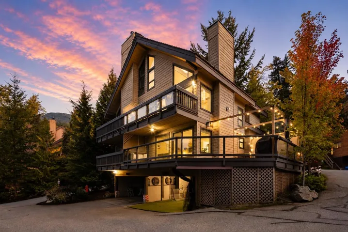 Multi-level contemporary home featuring extensive decking with glass railings