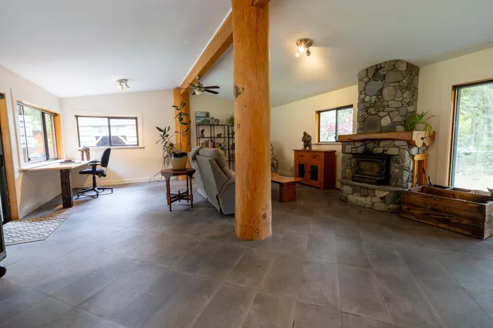 Living area featuring a ceiling fan, baseboards, and vaulted ceiling